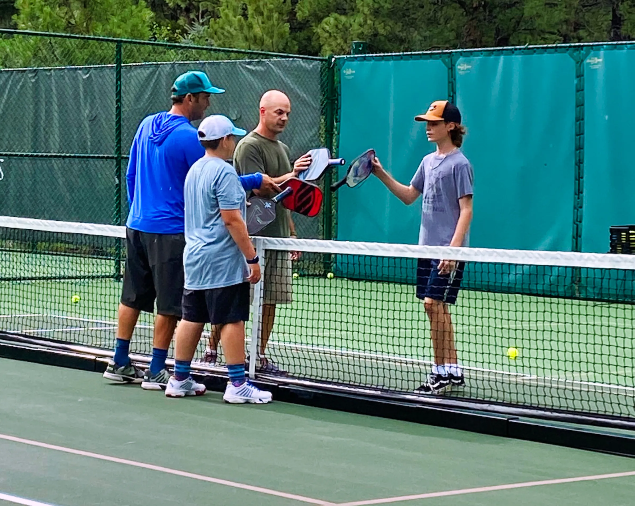 Coach mentoring young athletes on a tennis court